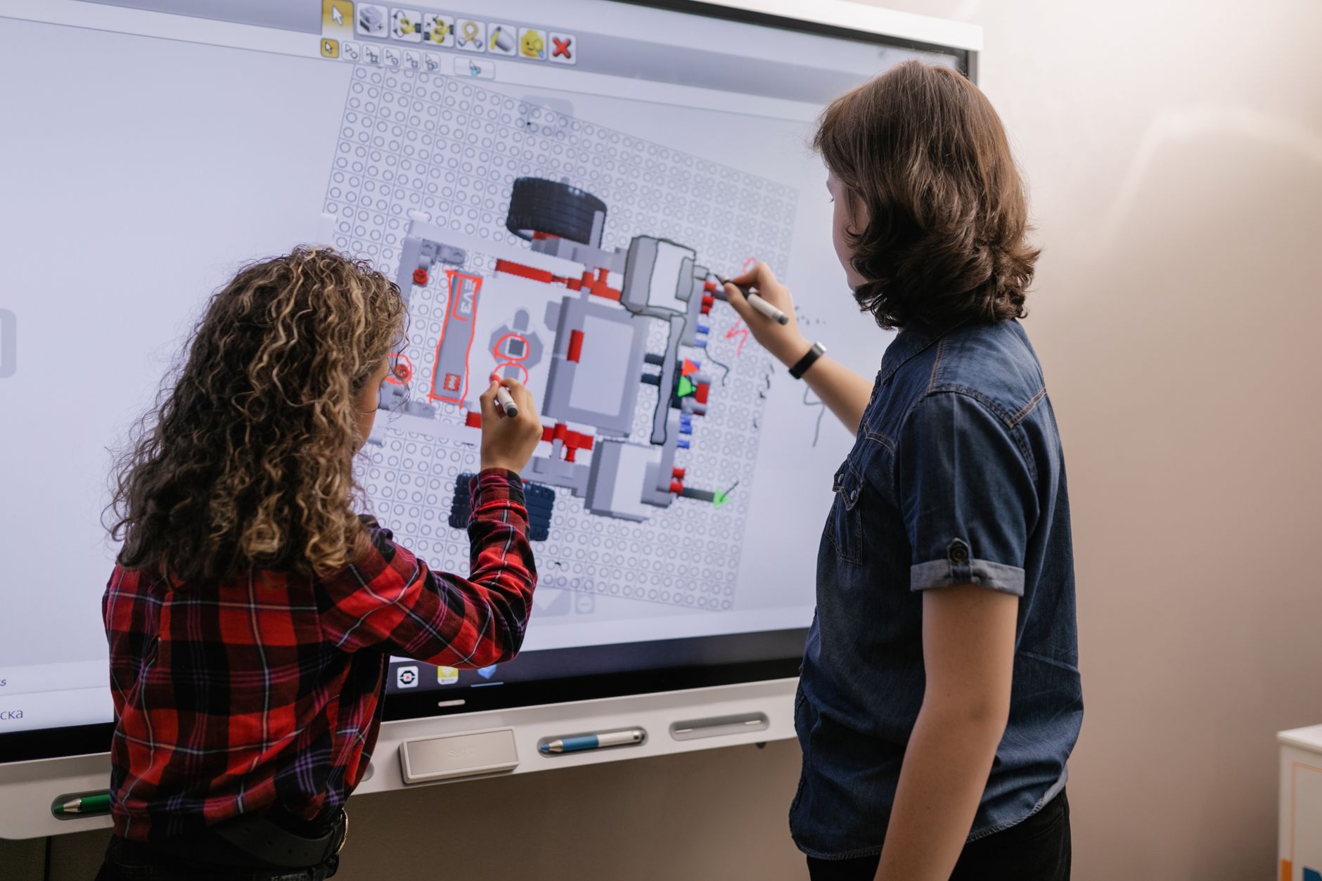 classe d’école avec enseignant utilisant un écran interactif tactile et élèves participant à une activité collaborative
